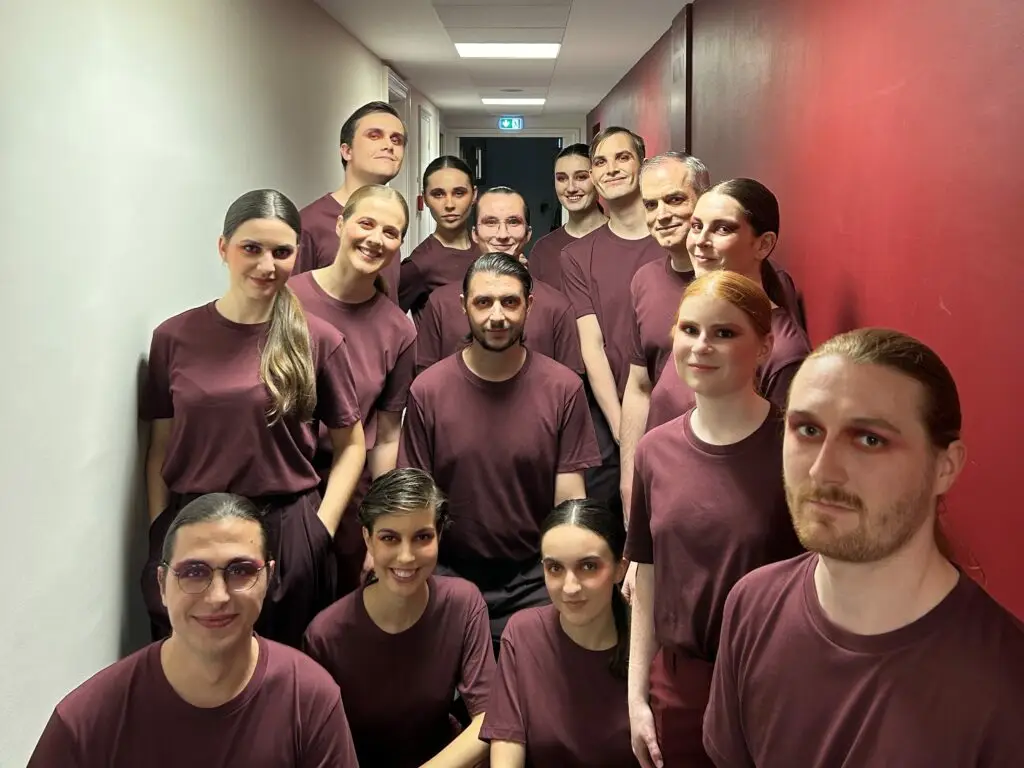 Les choristes du Chœur Ineffable, en tenue bordeaux assortie, posent dans les coulisses avant la prestation privée pour Hermès à l'Opéra de Lille.